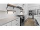 Contemporary kitchen featuring white subway tile, wooden shelves, and stainless steel gas range at 4412 N 203Rd Dr, Buckeye, AZ 85396