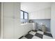 Bright laundry room with white cabinets and checkerboard floor at 4942 N Ascent Dr, Scottsdale, AZ 85251