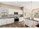 Modern kitchen features white cabinets, stainless steel appliances, and hardwood floors at 5077 S Barley Way, Gilbert, AZ 85298