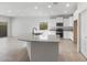 Bright kitchen featuring granite countertops, white cabinetry, and stainless steel appliances open to living area at 6383 W Georgetown Way, Florence, AZ 85132