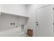 A dedicated laundry room featuring a utility sink, storage shelves and a side entry door at 6383 W Georgetown Way, Florence, AZ 85132