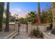 Charming courtyard entrance with decorative gate, red flowering bushes, and lush landscaping at 7500 E Mccormick Pkwy # 19, Scottsdale, AZ 85258