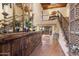 Grand foyer with terra cotta tile flooring, wooden console, view of staircase and wrought iron bannister at 7500 E Mccormick Pkwy # 19, Scottsdale, AZ 85258