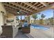 Covered patio featuring comfortable seating, an outdoor television, and a view of the refreshing pool at 7500 E Mccormick Pkwy # 19, Scottsdale, AZ 85258