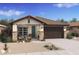 One-story home with brown garage door and teal front door at 7548 W Park St, Laveen, AZ 85339