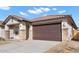 Attractive single-story home featuring a two-car garage, stone accents, and desert landscaping at 7548 W Park St, Laveen, AZ 85339