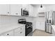 Modern kitchen featuring white cabinets, subway tile backsplash, and stainless steel appliances at 7548 W Park St, Laveen, AZ 85339