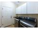 Bright laundry room with front loading washer/dryer, cabinets, and utility sink at 8923 E Mountain Spring Rd, Scottsdale, AZ 85255