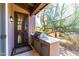 Covered outdoor kitchen area with stainless steel grill, counter space, and a gated entrance at 8923 E Mountain Spring Rd, Scottsdale, AZ 85255