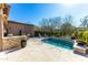 Backyard pool with travertine tile, poolside dining, and lounge furniture, perfect for relaxation at 8923 E Mountain Spring Rd, Scottsdale, AZ 85255