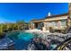 Beautiful backyard pool area with lounge chairs, dining set, and lush landscaping at 8923 E Mountain Spring Rd, Scottsdale, AZ 85255