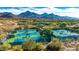 Aerial view of multiple green and blue tennis courts with mountain views at 8923 E Mountain Spring Rd, Scottsdale, AZ 85255