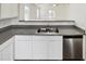 Kitchen with a double sink, white cabinets, and gray countertops at 9023 W Hubbell St, Phoenix, AZ 85037