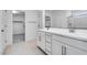 Well-lit bathroom with double sink vanity, walk-in shower and access to walk-in closet at 9054 S 169Th Dr, Goodyear, AZ 85338