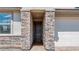 Close up of the front door with beautiful stone features surrounding the entrance at 9054 S 169Th Dr, Goodyear, AZ 85338