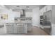 Modern kitchen with white cabinets, stainless steel appliances, and a stylish center island with seating at 9054 S 169Th Dr, Goodyear, AZ 85338