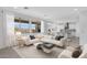 Open-concept living room with a modern sectional sofa, a view to the kitchen, and abundant natural light at 9054 S 169Th Dr, Goodyear, AZ 85338