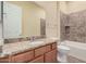 Well-lit bathroom features granite countertops, tiled shower over tub, and neutral color palette at 10501 W Swayback Pass, Peoria, AZ 85383