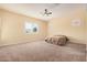 Bright bedroom featuring large windows, neutral carpet, and ceiling fan at 10501 W Swayback Pass, Peoria, AZ 85383