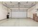 Garage with overhead storage racks, epoxy floors, and a new-looking garage door at 10501 W Swayback Pass, Peoria, AZ 85383