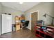 Well-lit home office with laminate floors, desk and door at 14701 W Sentinel Dr, Sun City West, AZ 85375