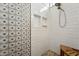 Bright shower with white subway tile, decorative accent wall, and river rock floor at 14701 W Sentinel Dr, Sun City West, AZ 85375