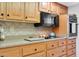Well-equipped kitchen with wood cabinets, granite counters, and modern appliances at 15809 N Bowling Green Dr, Sun City, AZ 85351