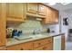 Kitchen boasts ample wood cabinets, granite countertops, and a double sink at 15809 N Bowling Green Dr, Sun City, AZ 85351