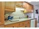 Kitchen with wood cabinets, granite countertops, and a double sink at 15809 N Bowling Green Dr, Sun City, AZ 85351