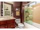 Bathroom featuring a shower and bath combination with glass doors, single sink, and a chocolate-colored wall at 16442 W Berkeley Rd, Goodyear, AZ 85395