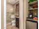 Half bath with glass door walk-in shower, wood-look flooring, and built-in storage shelves at 16442 W Berkeley Rd, Goodyear, AZ 85395