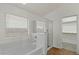 Bright bathroom with a soaking tub and a separate glass-enclosed shower, leading to a walk-in closet at 17750 W Watson Ln, Surprise, AZ 85388