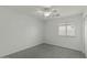 Bedroom with neutral walls, carpeted floors, a ceiling fan, and a large window, creating a comfortable and serene ambiance at 17750 W Watson Ln, Surprise, AZ 85388