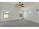 Bright bedroom with neutral carpet, ceiling fan and windows offering plenty of natural light at 17750 W Watson Ln, Surprise, AZ 85388
