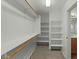 Spacious walk-in closet featuring built-in shelves and rods for ample storage, carpeted flooring, and bright lighting at 17750 W Watson Ln, Surprise, AZ 85388