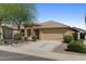 Attractive home with a spacious driveway, a two-car garage, and desert landscaping creating a serene environment at 17750 W Watson Ln, Surprise, AZ 85388
