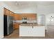 Well-lit kitchen features stainless steel appliances, light wood cabinets, and a kitchen island at 17750 W Watson Ln, Surprise, AZ 85388