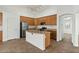 Well-lit kitchen features stainless steel appliances, light wood cabinets, and a kitchen island at 17750 W Watson Ln, Surprise, AZ 85388