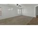 Spacious living room featuring plush carpeting, freshly painted white walls, and natural lighting at 17750 W Watson Ln, Surprise, AZ 85388