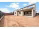 Home backyard featuring stucco siding, windows, patio, and dirt at 17857 W Getty Dr, Goodyear, AZ 85338