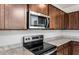 Close-up view of a modern kitchen with stainless steel microwave and electric cooktop stove at 17857 W Getty Dr, Goodyear, AZ 85338