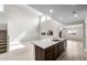 Bright, open kitchen with stainless steel sink on island, tile floors, and high ceilings at 17857 W Getty Dr, Goodyear, AZ 85338