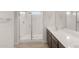 Bathroom featuring a glass shower, double sinks, and modern cabinets at 17875 W Getty Dr, Goodyear, AZ 85338