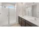 Bathroom featuring a glass shower, double sinks, and dark wood cabinets at 17875 W Getty Dr, Goodyear, AZ 85338