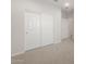 Hallway featuring carpet and multiple doors with white trim at 17875 W Getty Dr, Goodyear, AZ 85338
