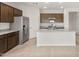 Stylish kitchen with stainless appliances, wood cabinets, a center island, and tile flooring at 17875 W Getty Dr, Goodyear, AZ 85338