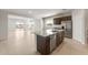 Open kitchen with an island, stainless appliances, dark wood cabinets, and tile flooring at 17875 W Getty Dr, Goodyear, AZ 85338