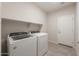 Well-equipped laundry room featuring a modern washer, dryer, and convenient overhead shelving for storage solutions at 17875 W Getty Dr, Goodyear, AZ 85338