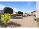 Expansive backyard featuring a brick patio, dining area, grill, and decorative landscaping at 18017 W Desert Ln, Surprise, AZ 85388