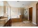 Bathroom featuring dual sinks, a separate shower and tub, and neutral color scheme at 18017 W Desert Ln, Surprise, AZ 85388